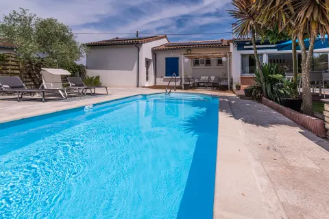 Piscine privée, bains de soleil et coin repas ombragé sur la terrasse