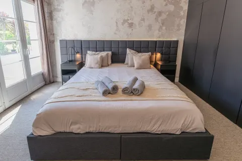 Chambre avec lit king, porte-fenêtre et grands rangements