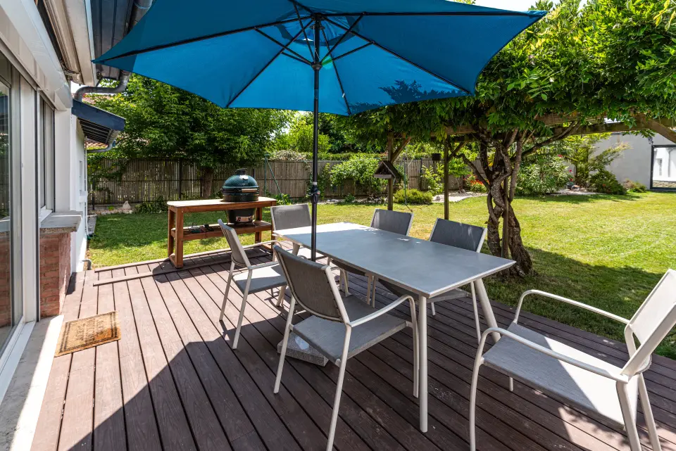 La terrasse côté jardin, son coin repas ombragé et le barbecue